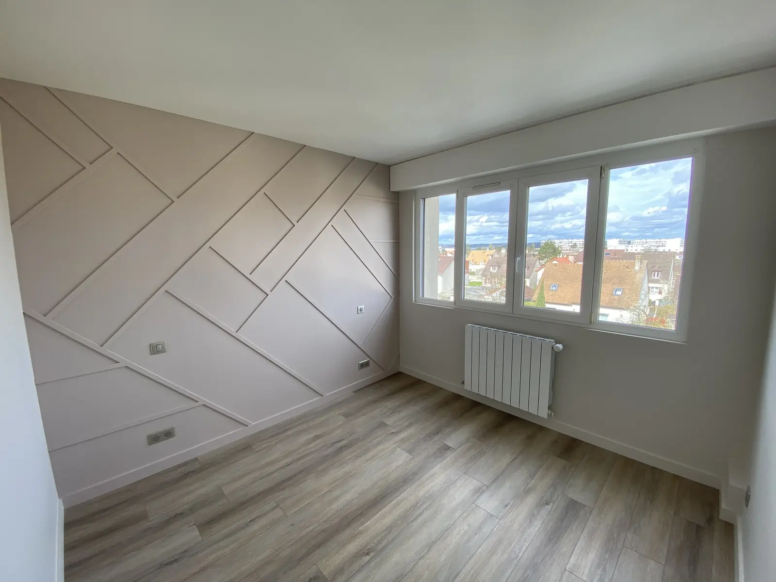 Chambre rénovée avec un mur en tasseaux peint en taupe, les autres murs en gris clair et parquet immitation bois.