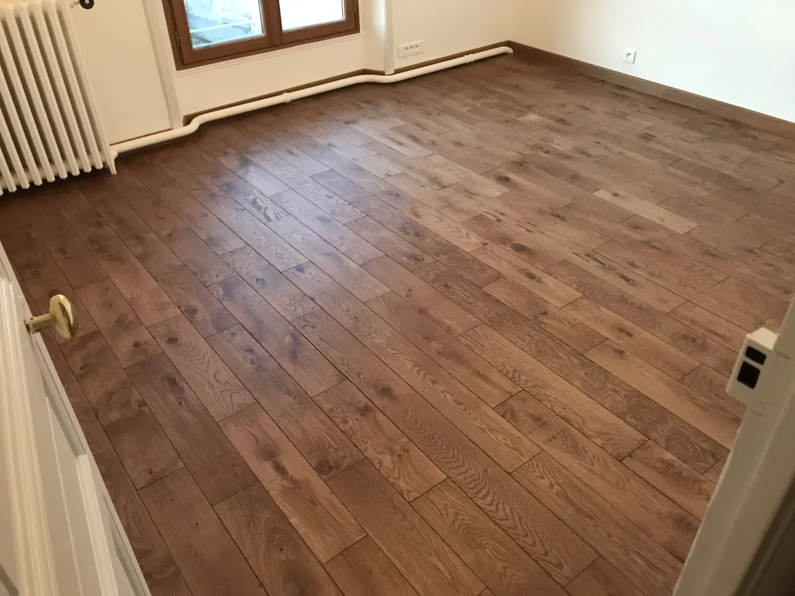 Sol en parquet collé, pose droite. De couleur brun, le parquet donne une impression de chaleur et d'élégance à la pièce.