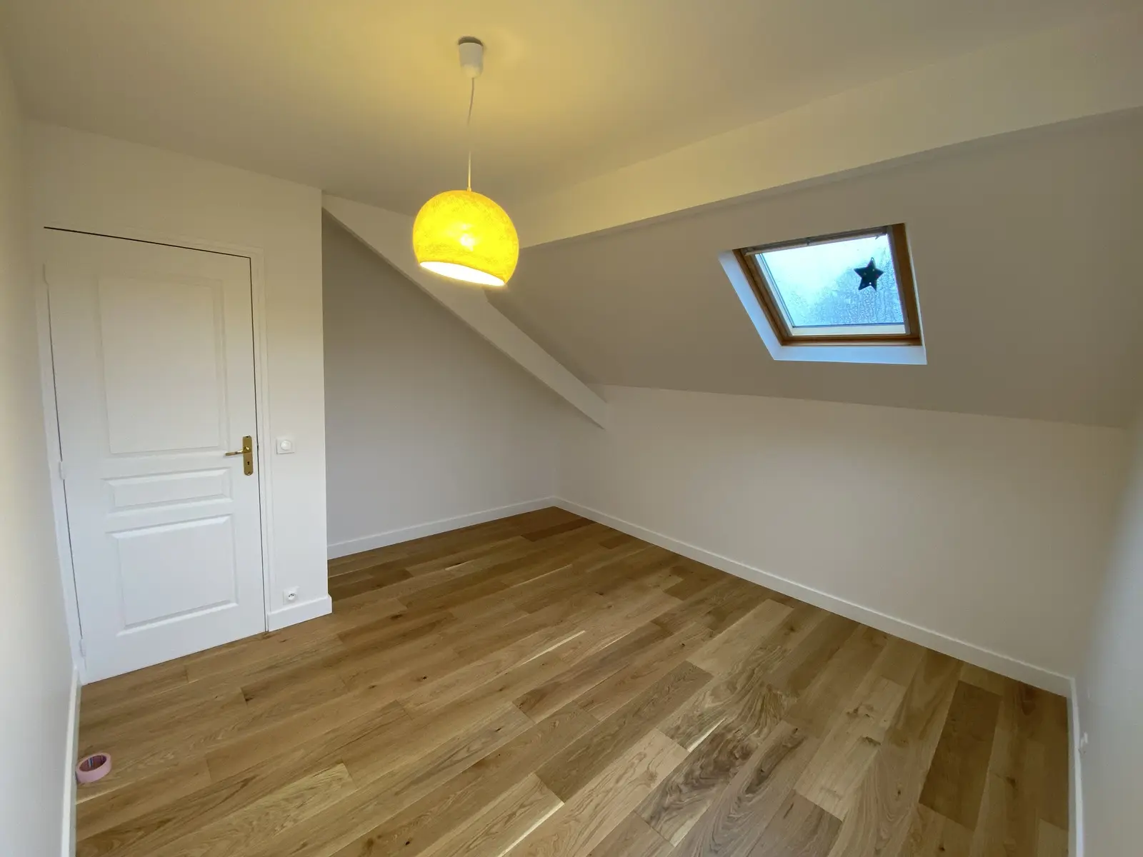 Parquet flottant en bois clair, pose droite. Finition élégante et uniforme, lames bien ajustées pour un rendu harmonieux.