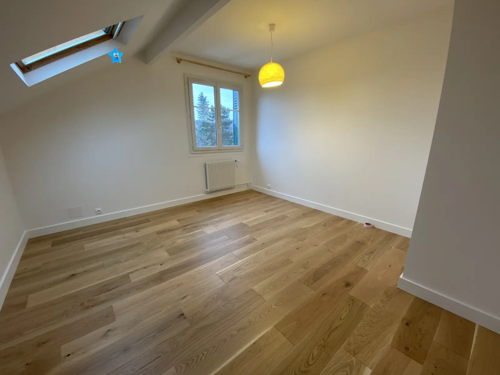 Parquet flottant clair, installé en pose droite. Lames sans défauts d'espacement, travail net et professionnel.