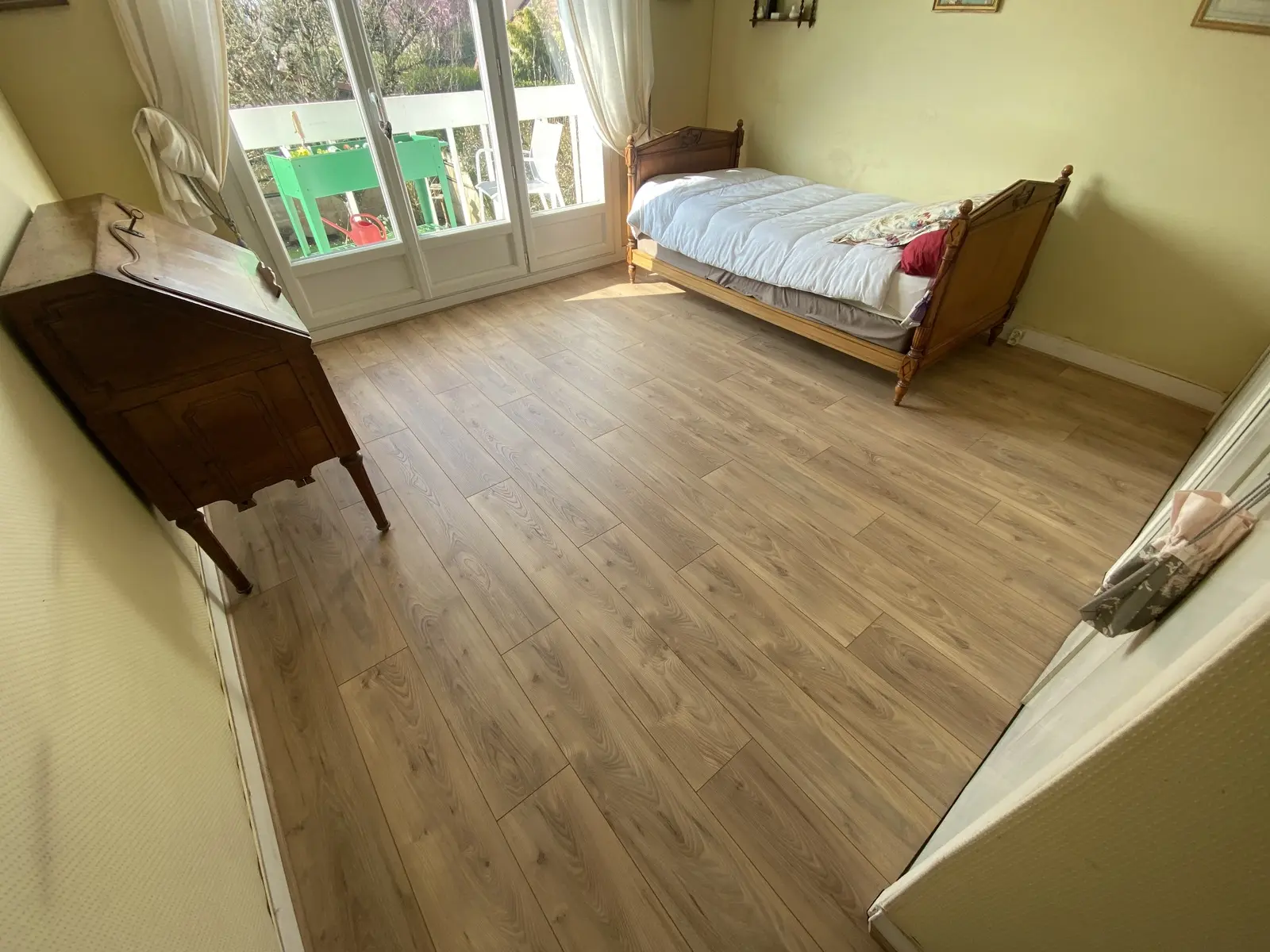 Parquet stratifié blanc en pose droite. Aspect propre et lumineux, lames parfaitement ajustées pour un rendu élégant et moderne.