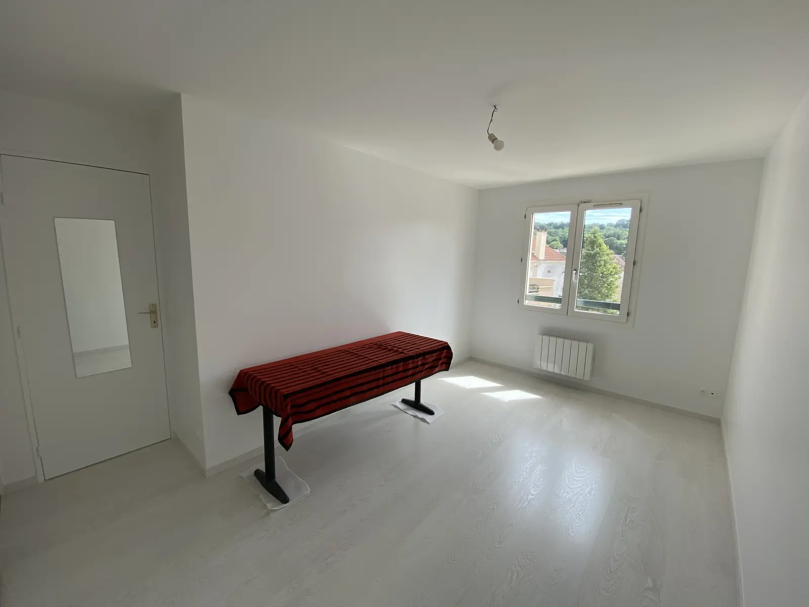 Intérieur lumineux aux murs blancs, sol clair effet bois