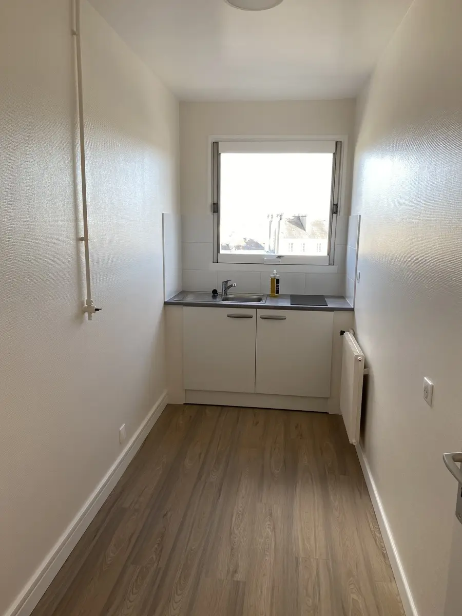 Kitchenette avec murs recouverts de toile de verre. Revêtement posé proprement, surface uniforme et finitions soignées